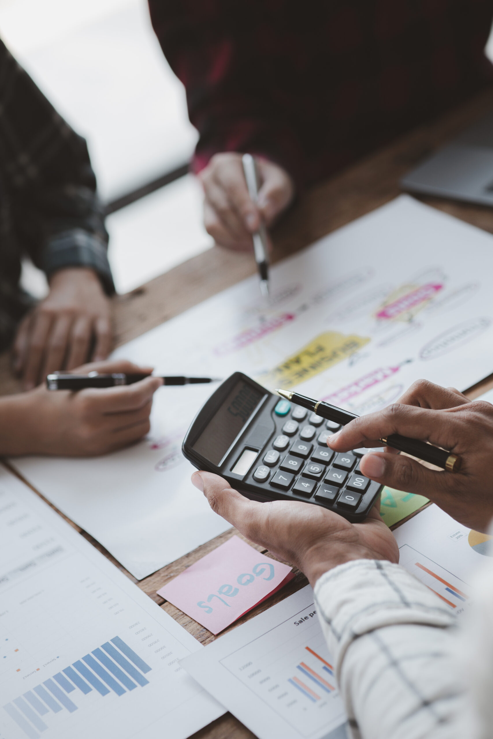 Company meeting room has businessmen and finance managers meeting together on finance topics, they are looking at information on documents and discussing together. Concept company financial management