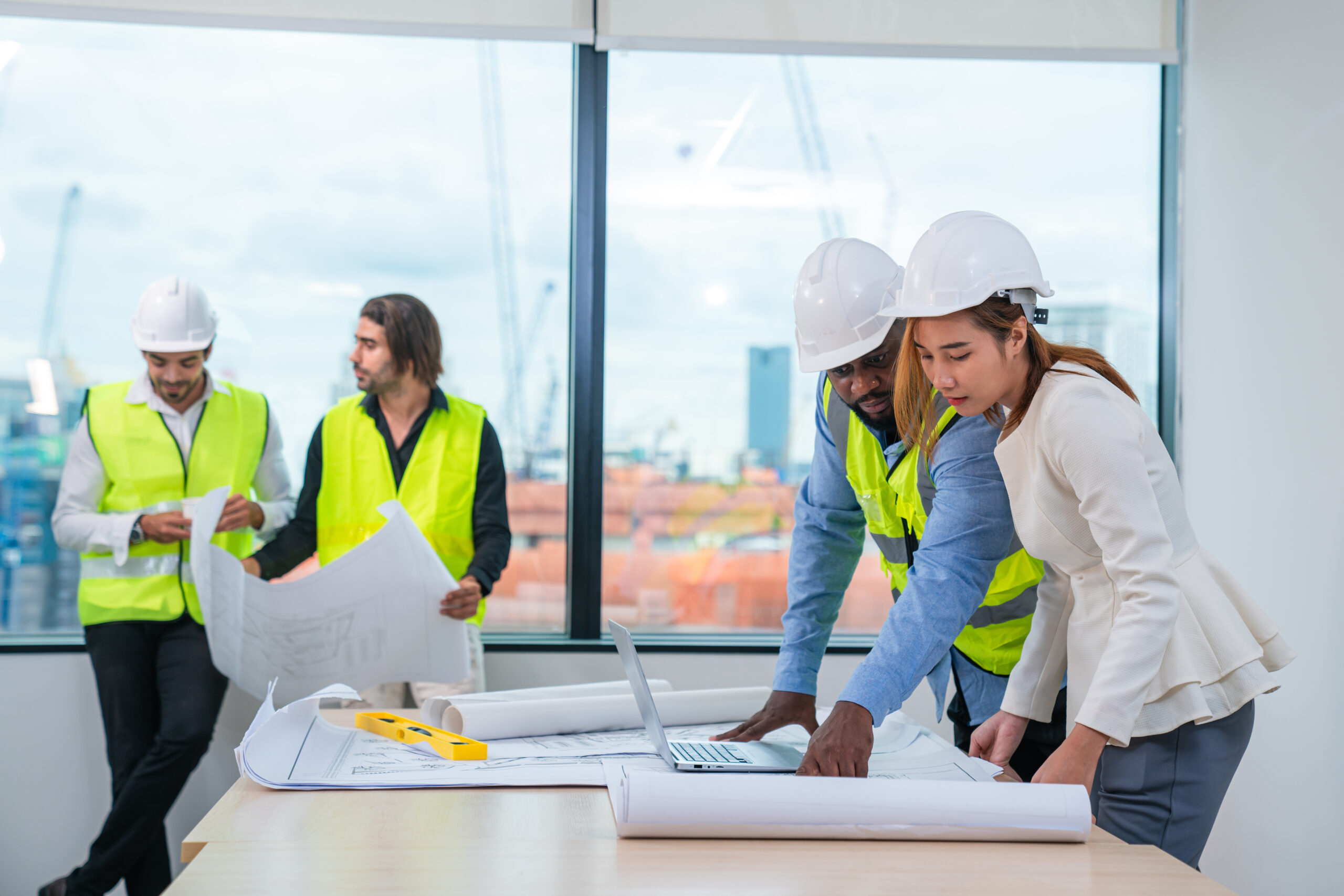 Female inspectors and architects discuss with head engineer about construction project, team discussion with construction on site work.